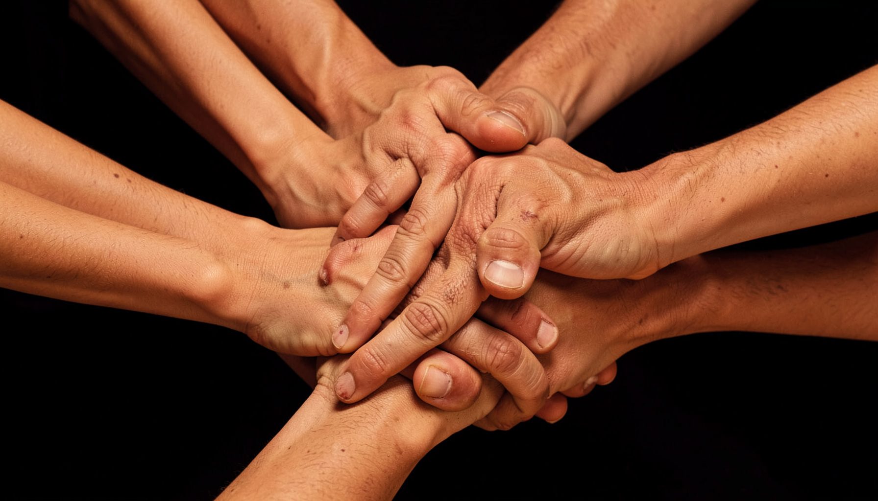 Abstract composition of overlapping hands in warm earth tones against a dark background, conveying unity and collective action
